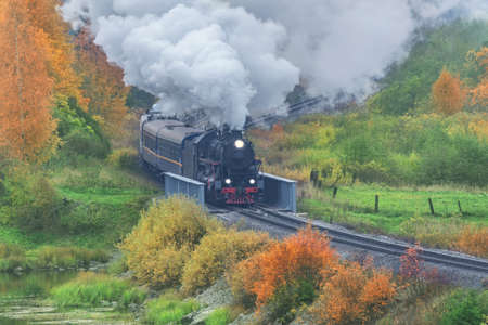 Retro steam train at autumn cloudy morning.の写真素材