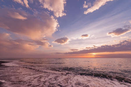 Sunset sky over the calm surface of the sea.の写真素材