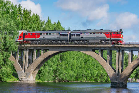 Passenger intercity train moves above the river.の写真素材