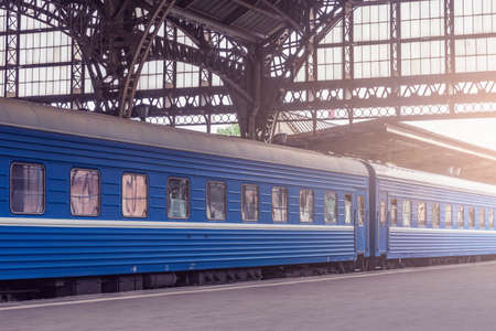 Train stands by the platform before departure at sunset.の写真素材