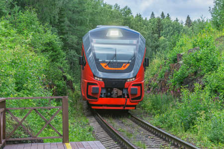 Passenger train approaches to the wooden platform.の写真素材