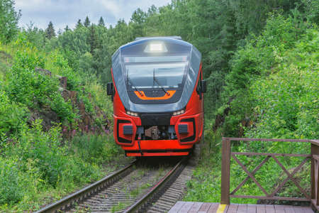 Passenger train approaches to the wooden platform.の写真素材
