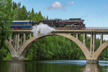 Steam retro train moves on the bridge.の写真素材