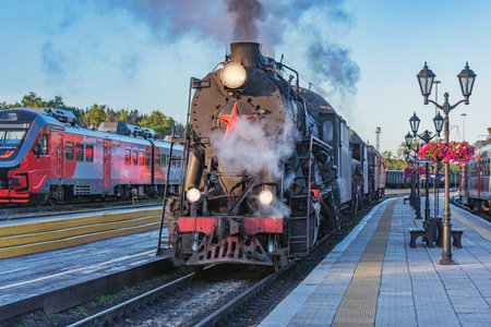 Steam locomotives stand by the wooden station platform.の写真素材