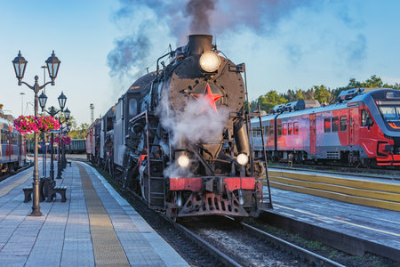 Steam locomotives stand by the wooden station platform.の写真素材