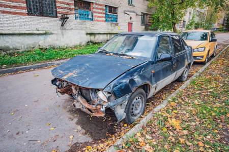Destroyed car on the dirty suburban street.の写真素材