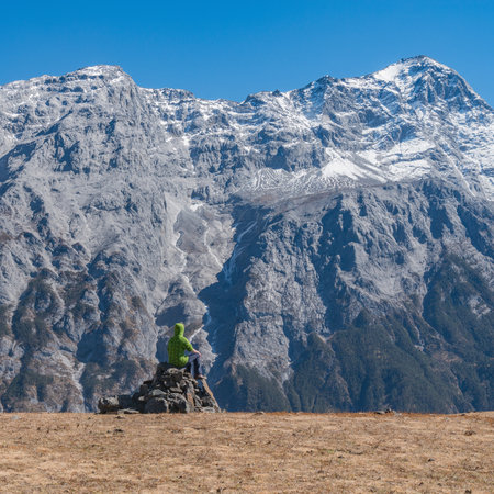 Young woman sits on the stone in the mountain valley.の写真素材