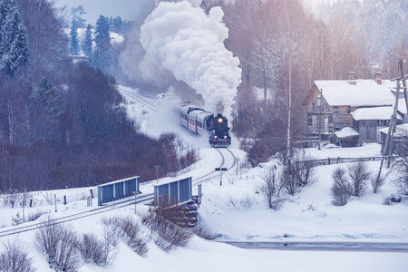 Retro steam train moves at winter sunset.の写真素材