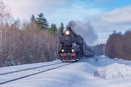 Retro steam train moves at winter day.の写真素材