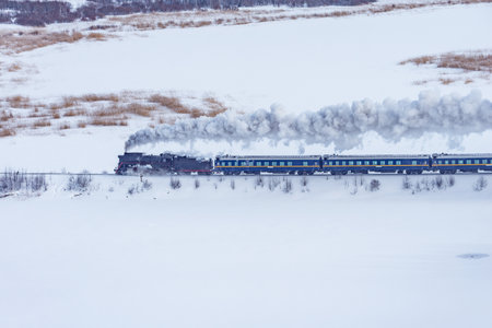 Retro steam train moves at winter morning time.の写真素材
