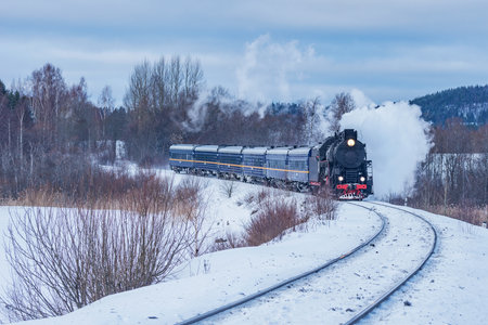 Retro steam train moves at winter morning time.の写真素材