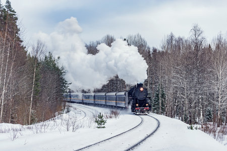 Retro steam train moves at winter morning time.の写真素材