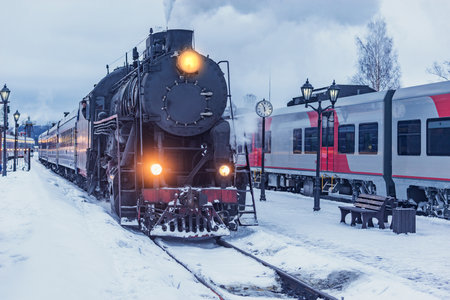 Retro steam train arrives at winter morning time.の写真素材