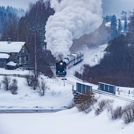 Retro steam train moves at winter morning time.の写真素材