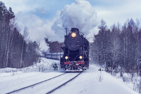 Retro steam train moves at winter morning time.の写真素材