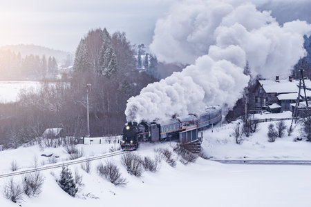Retro steam train moves at winter morning.の写真素材