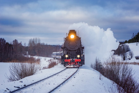 Retro steam train moves at winter morning time.の写真素材