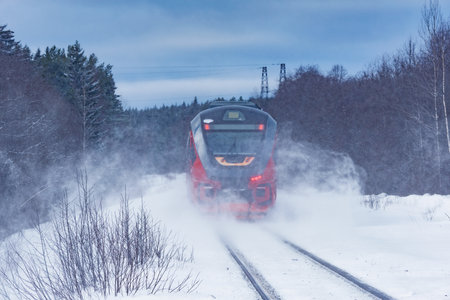 Passenger train moves fast at winter day.の写真素材