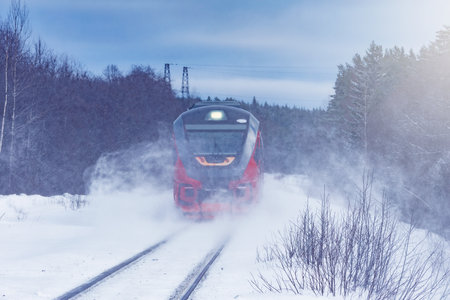 Passenger train moves fast at winter day.の写真素材