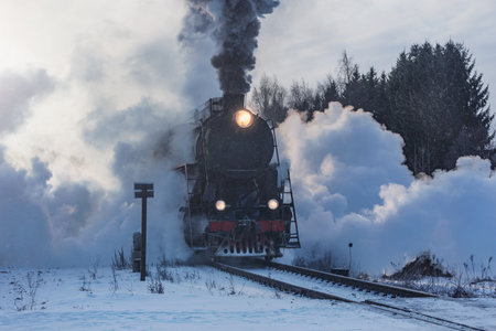 Retro steam train moves at winter morning.の写真素材