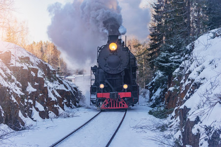 Retro steam train moves at winter morning.の写真素材