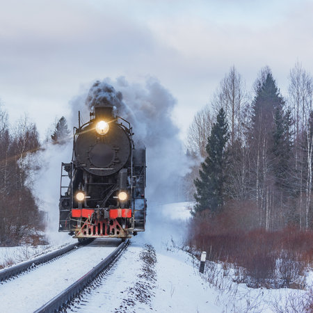 Retro steam train arrives at winter morning.