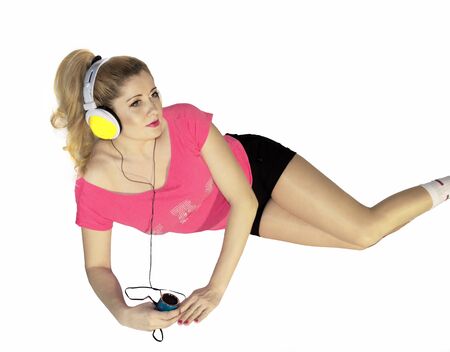 the woman in pink, lying listens to musicの写真素材