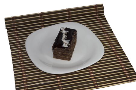 brown cake with pearls on a plate, on a brown rugの写真素材
