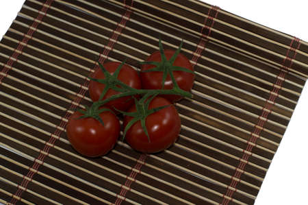 four red tomatoes on a brown rugの写真素材