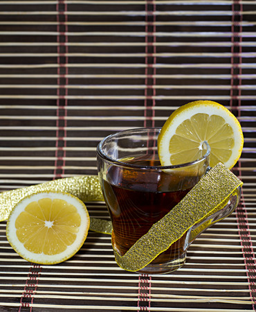 cup of tea with a lemon wrapped up by a gold tapeの写真素材