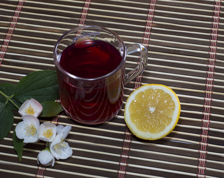 glass of red tea with a lemon on a rugの写真素材