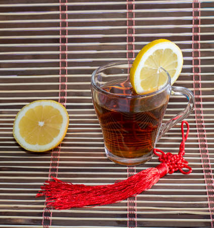 glass of tea and nearby lemon, on a rugの写真素材