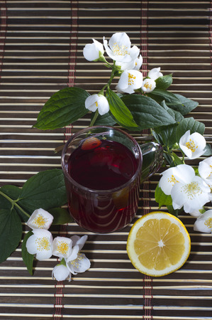 glass of red tea, nearby lemon and flowerの写真素材