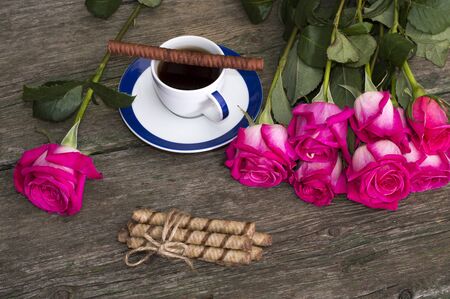 still life pink roses row coffee and cookiesの写真素材