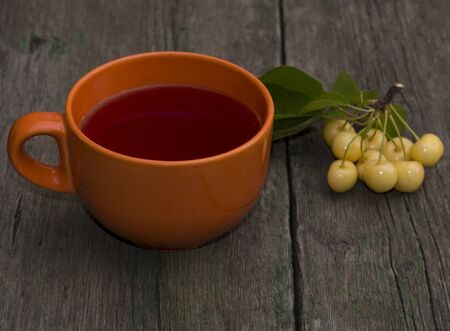 big orange mug of juice and berry of white sweet cherryの写真素材
