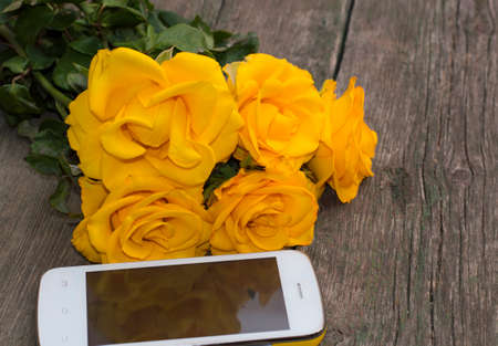 bouquet of yellow roses and their reflection in the phoneの写真素材