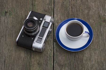 retro the camera and a cup of black coffee on a tableの写真素材