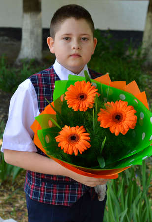 the school student with a bouquet of bright flowers near schoolの写真素材