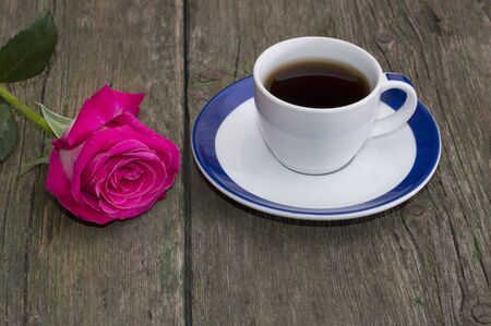 cup of coffee and lonely red rose on a tableの写真素材