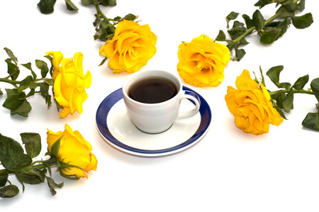 five yellow roses round a cup of coffeeの写真素材