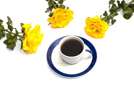 cup of coffee and three yellow roses round itの写真素材