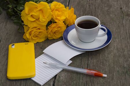 yellow roses, notebook, coffee and yellow phoneの写真素材