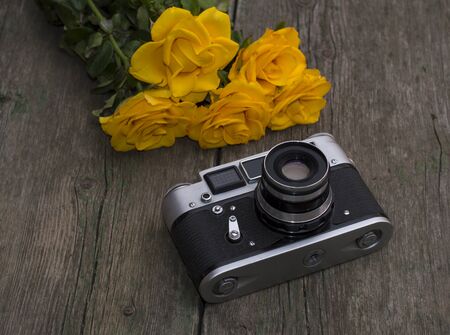 film retro camera and bouquet of yellow roses, subject festive card, flowersの写真素材