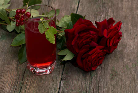 glass of juice, currant and bouquet of brightly red roses, subject drinks and flowersの写真素材