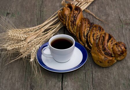Still Life coffee, roll with poppy seeds and cereal ears, the theme of food and beveragesの写真素材