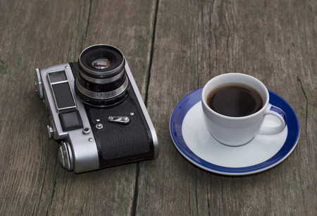 the old camera and cup of coffee on a wooden table, a retro subjectの写真素材