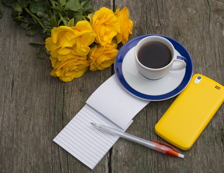 coffee still life yellow roses, phone and notebook, top view, subject beautiful flowers and drinks, greeting cardの写真素材
