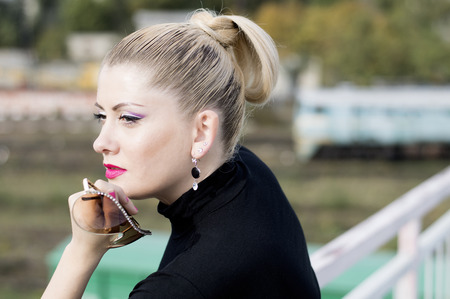 portrait of the beautiful woman against the moving train, a scene over the railroad, a subject fashionable women in unusual placesの写真素材