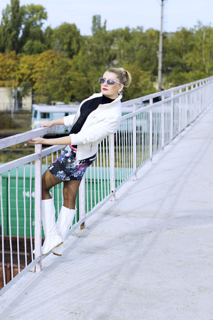 the beautiful woman in mini, on on the bridge over the railroad, a subject fashionable women in unusual placesの写真素材