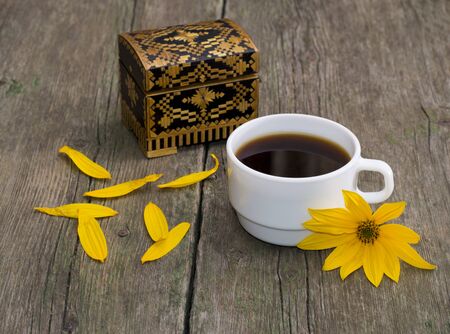 cup of coffee, petals, casket and yellow flower, still life, on a wooden table, a subject flowers and drinksの写真素材